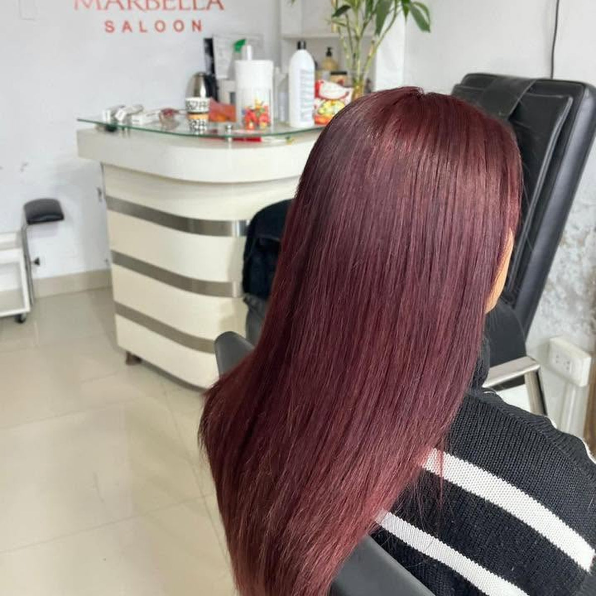 Tinte completo color borgoña en cabello largo y liso, en el salón Marbella Saloon